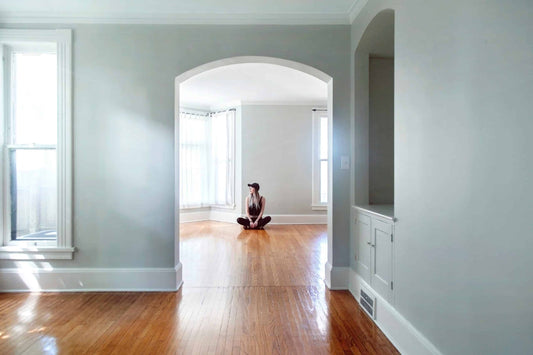 Woman sitting on the floor in an empty room of a house