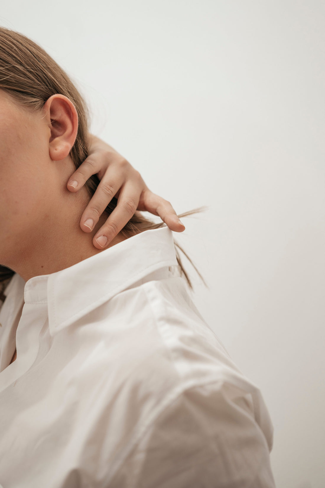 image of woman with neck pain touching her neck