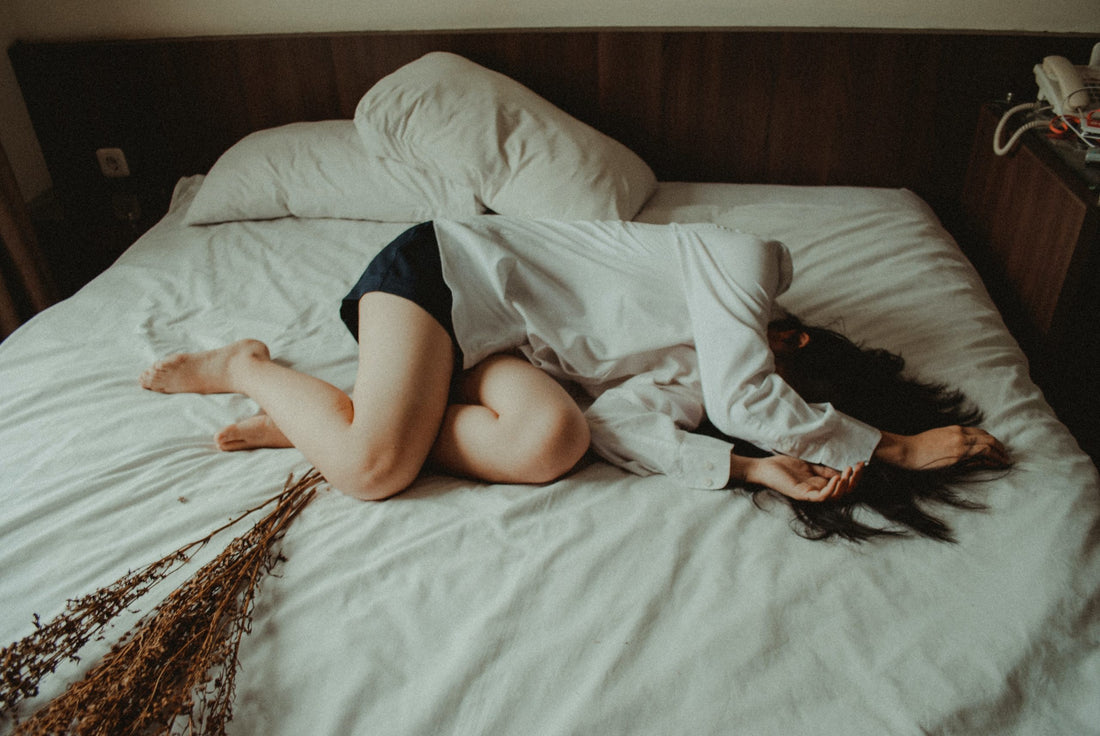 Image of a woman lying sideways on a bed clearly uncomfortable